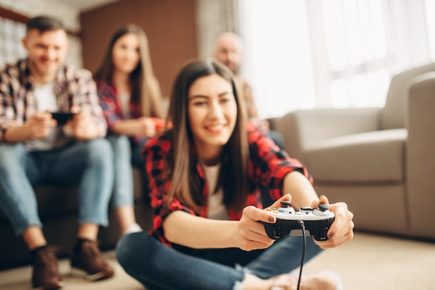 Gli amici con i joystick giocano alla console della tv a casa