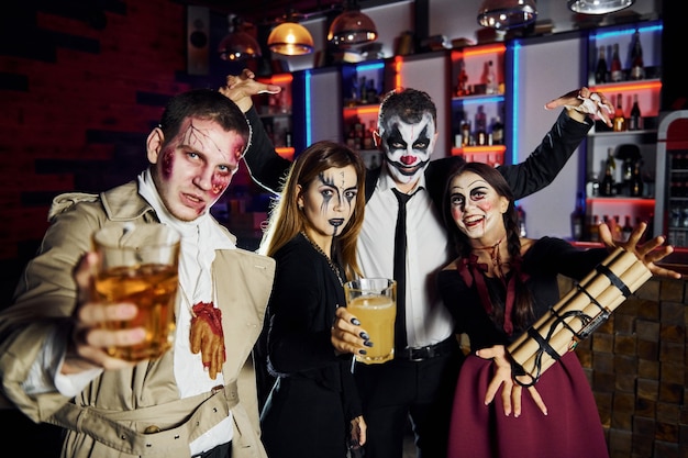 Gli amici con la bomba in mano sono alla festa di halloween a tema con trucco e costumi spaventosi.