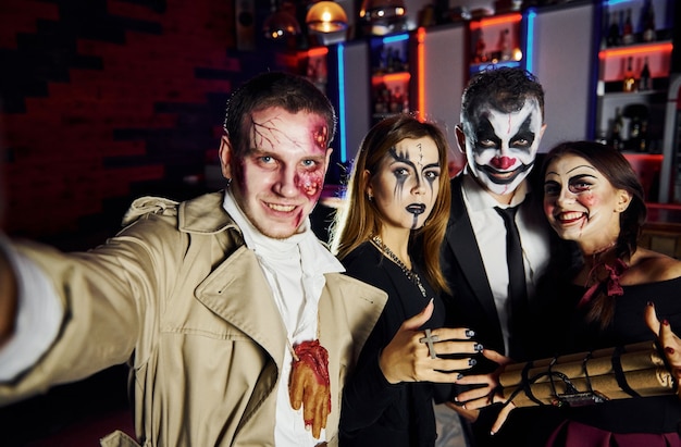 Gli amici con la bomba in mano sono sulla festa di halloween a tema con trucco e costumi spaventosi.