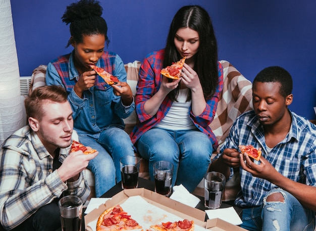 Gli amici della compagnia mangiano la pizza Pranzo a casa Goditi l'amicizia di gruppo Cibo malsano internazionale Fastfood Concept