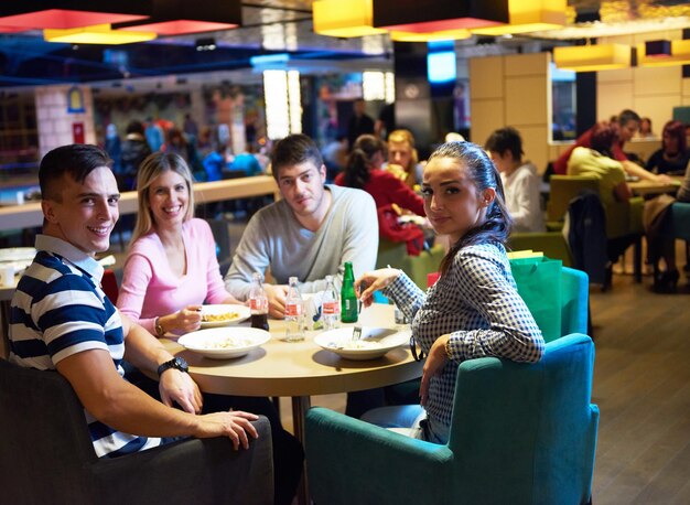 gli amici fanno una pausa pranzo nel centro commerciale, mangiando fast food italiano