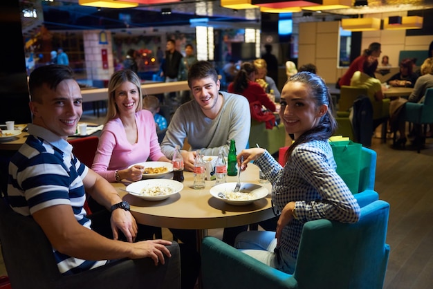 gli amici fanno una pausa pranzo nel centro commerciale, mangiando fast food italiano