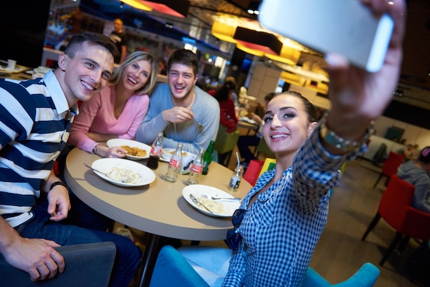 gli amici fanno una pausa pranzo nel centro commerciale, mangiando fast food italiano