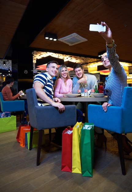 gli amici fanno una pausa pranzo nel centro commerciale, mangiando fast food italiano