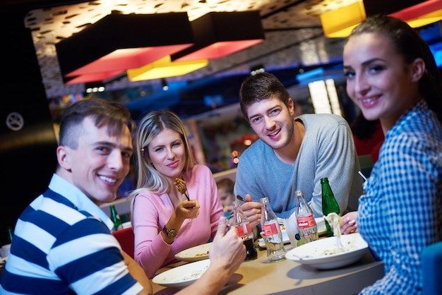gli amici fanno una pausa pranzo nel centro commerciale, mangiando fast food italiano