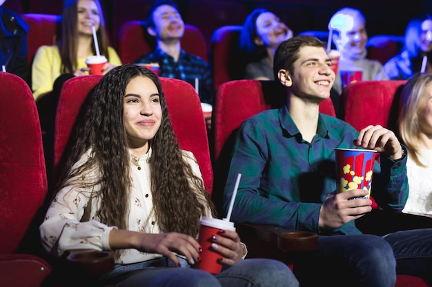 Gli amici si siedono e mangiano popcorn insieme mentre guardano film in un cinema