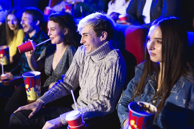 Gli amici si siedono e mangiano popcorn insieme mentre guardano film in un cinema