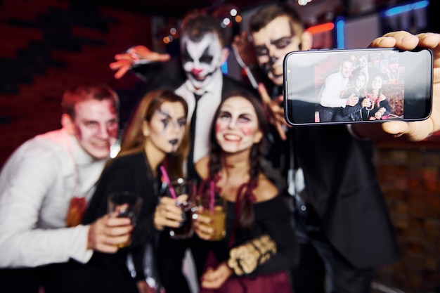 Gli amici sono alla festa tematica di Halloween con trucco e costumi spaventosi.