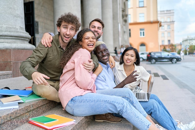 Gli amici studenti si divertono a sedersi sui gradini