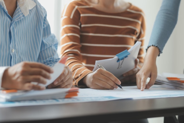 Gli analisti finanziari analizzano i rapporti finanziari aziendali su un tablet digitale pianificando un progetto di investimento durante una discussione in una riunione aziendale che mostra i risultati del loro lavoro di squadra di successo