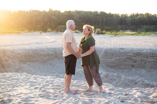 Gli anziani attivi che baciano in natura dell'estate, le coppie senior si rilassano nell'ora legale. Le coppie anziane di amore di pensionamento di stile di vita di sanità insieme