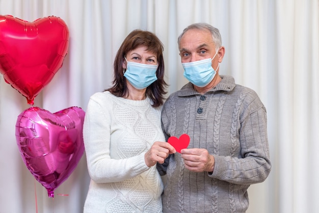 Gli anziani delle coppie felici celebrano il giorno di San Valentino in maschera.