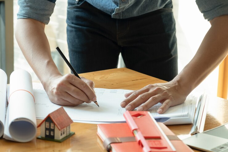 Gli architetti scrivono disegni per la casa sulla scrivania.