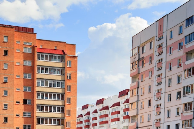 Gli edifici a più piani sono vicini l'uno all'altro, case bianche e rosse contro un concetto di alloggi in cielo