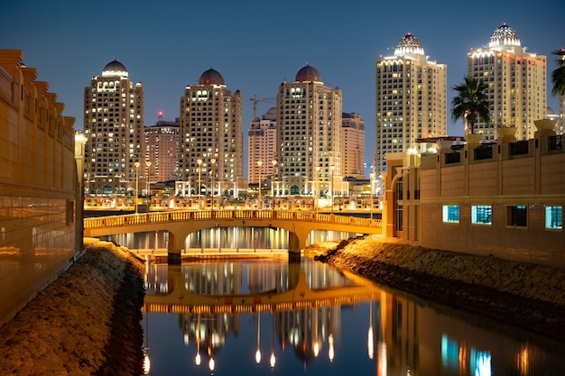 Gli edifici della zona Pearl-Qatar con ponte e acqua a Doha, in Qatar.