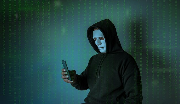 Gli hacker di Hood utilizzano il cellulare per attaccare i dati sensibili nel codice binario di sfondo della carta di credito Concetto di hacking e malware