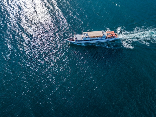 Gli immigrati dei rifugiati nella vista aerea della nave del traghetto nel concetto del mare