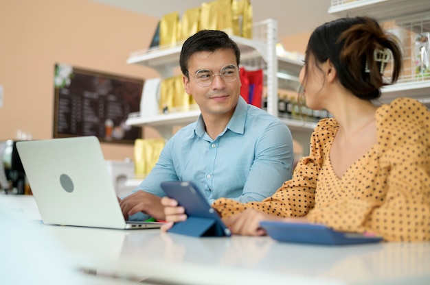 Gli imprenditori stanno analizzando i dati aziendali, parlando e sorridendo in un negozio moderno