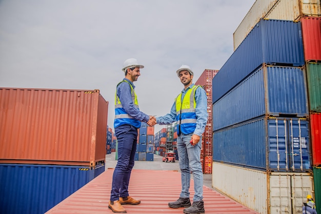 Gli ingegneri del team stanno ispezionando il trasporto di merci con container all'interno del magazzino Container in attività di esportazione e importazione e logistica