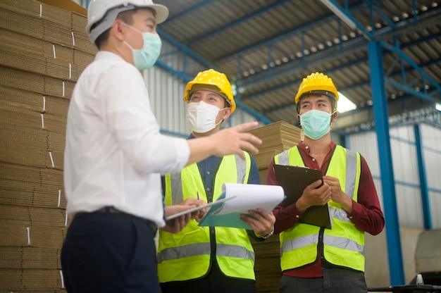 Gli ingegneri indossano una maschera protettiva che lavorano in magazzino