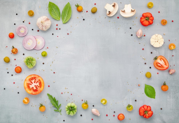 Gli ingredienti per la pizza fatta in casa con vassoio per pizza in legno allestito su sfondo grigio vista dall'alto