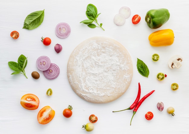 Gli ingredienti per la pizza fatta in casa su fondo di legno bianco.