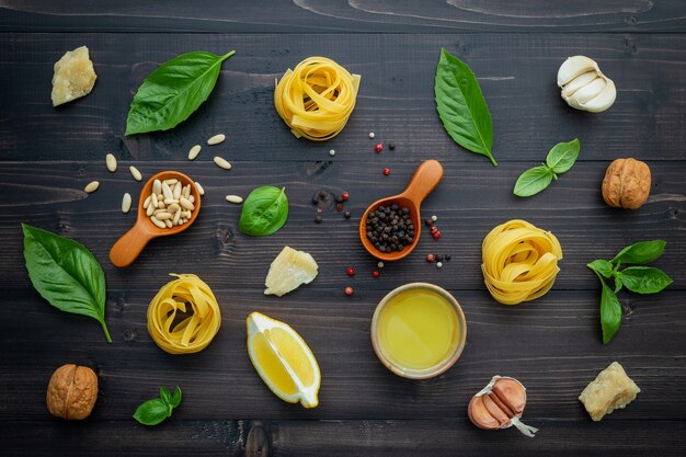 Gli ingredienti per la salsa di pesto verde su fondo di legno scuro.