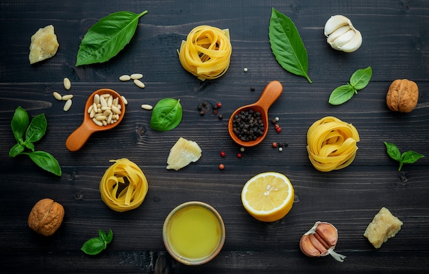 Gli ingredienti per la salsa di pesto verde su fondo di legno scuro.