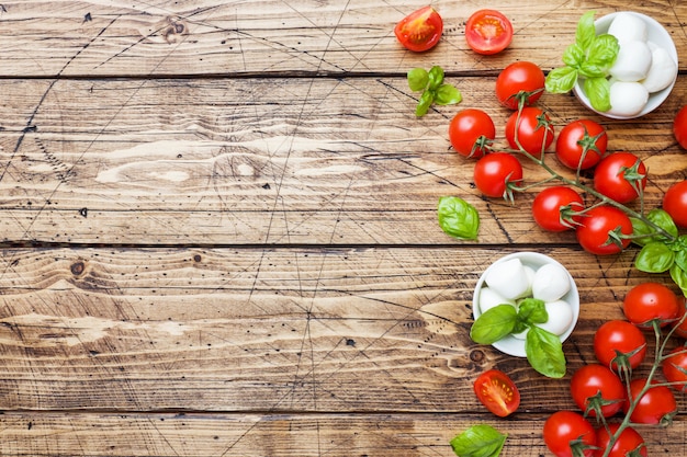 Gli ingredienti per un&#39;insalata caprese. Basilico, palline di mozzarella e pomodori con lo spazio della copia.