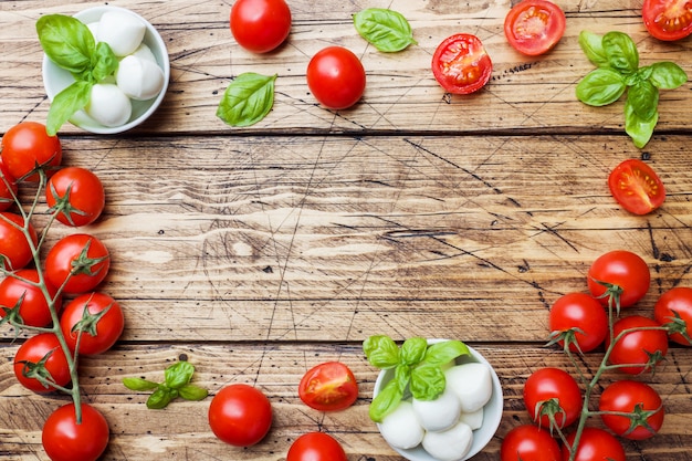 Gli ingredienti per un&#39;insalata caprese. Basilico, palline di mozzarella e pomodori con lo spazio della copia.