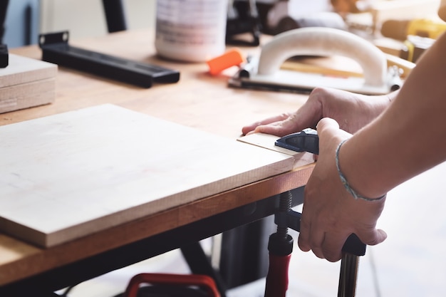 Gli operatori di falegnameria stanno decorando pezzi di legno per assemblare e costruire tavoli in legno per i clienti