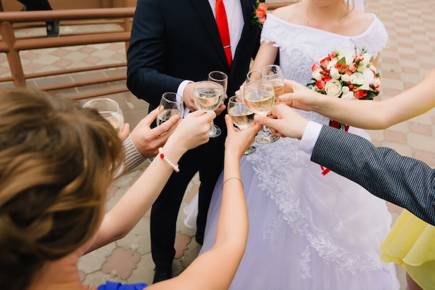 Gli ospiti del matrimonio tintinnano di bicchieri di champagne e si congratulano