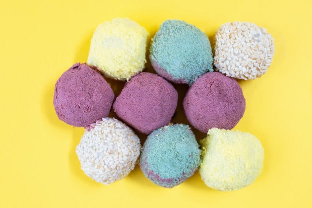 Gli snack di riso colorati dolci tradizionali coreani tteok isolano su sfondo giallo