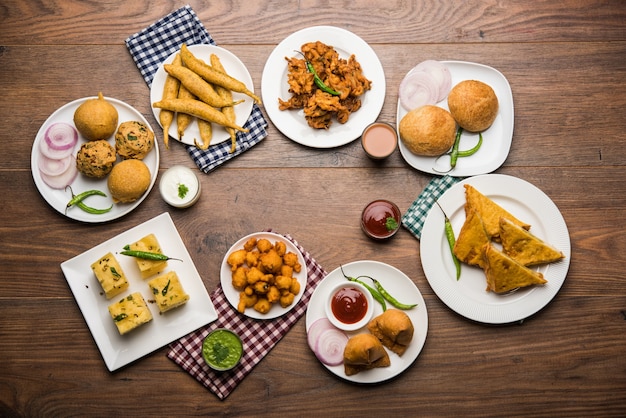 Gli snack indiani dell'ora del tè in gruppo includono Veg Samosa, Kachori, kachaudi, aloo bonda, khaman dhokla, pane, cipolla, peperoncino e moong pakora, pakoda, bhaji, bhajji, Bhajiya, bajji con salse