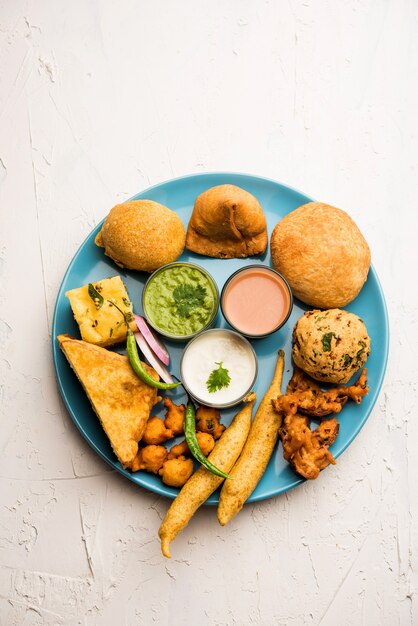 Gli snack indiani dell'ora del tè in gruppo includono Veg Samosa, Kachori, kachaudi, aloo bonda, khaman dhokla, pane, cipolla, peperoncino e moong pakora, pakoda, bhaji, bhajji, Bhajiya, bajji con salse