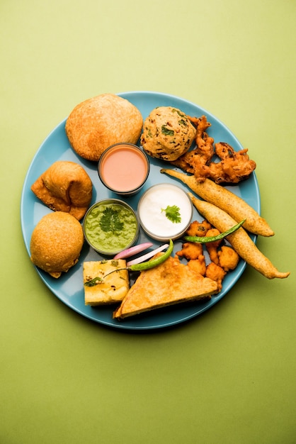 Gli snack indiani dell'ora del tè in gruppo includono Veg Samosa, Kachori, kachaudi, aloo bonda, khaman dhokla, pane, cipolla, peperoncino e moong pakora, pakoda, bhaji, bhajji, Bhajiya, bajji con salse