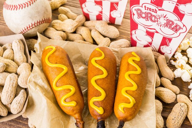 Gli snack tradizionali della giornata di gioco includevano corndog e arachidi salate su una tavola di legno.