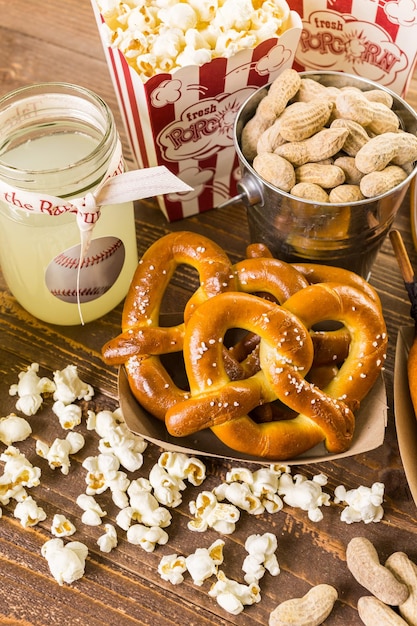 Gli snack tradizionali della giornata di gioco includevano corndog e arachidi salate su una tavola di legno.