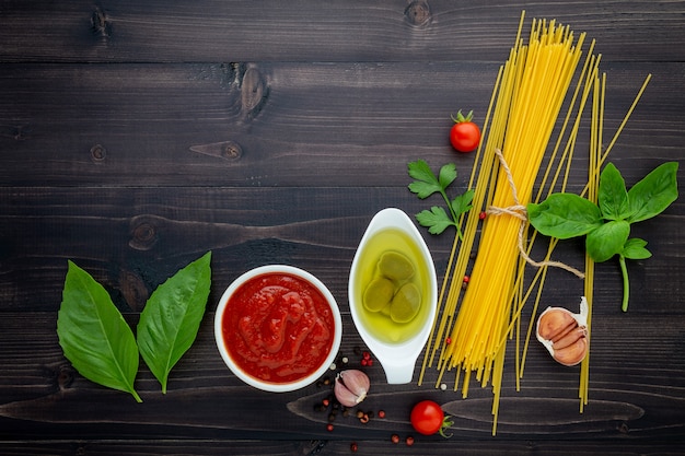 Gli spaghetti sottili su fondo di legno nero.