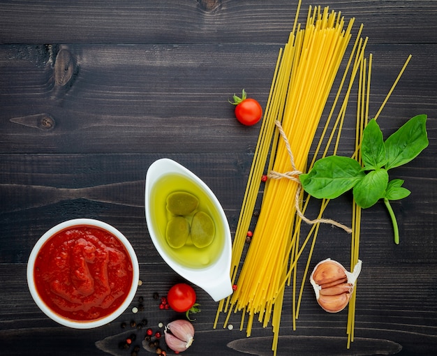 Gli spaghetti sottili su fondo di legno nero.