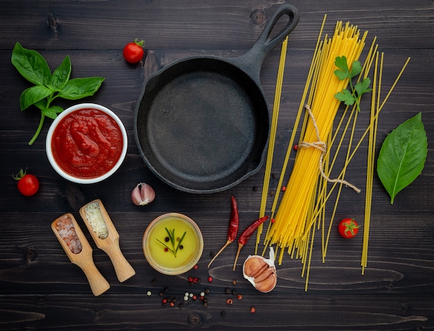 Gli spaghetti sottili su fondo di legno nero.