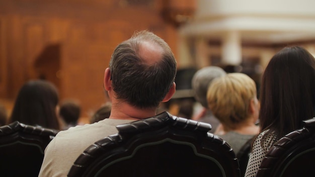 Gli spettatori stanno guardando lo spettacolo teatrale uomo calvo