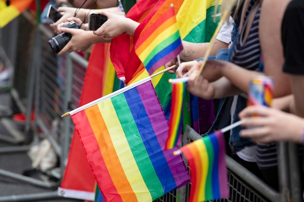 Gli spettatori sventolano una bandiera arcobaleno gay a un evento della comunità del gay pride lgbt