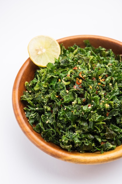 Gli Spinaci Croccanti o Palak Croccanti sono un antipasto indiano, servito in una ciotola o un piatto con una fetta di limone