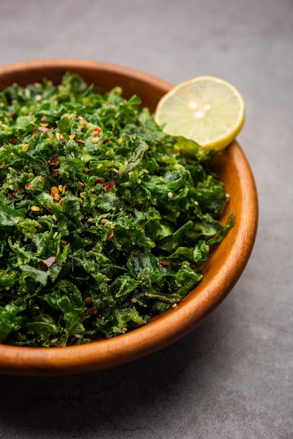 Gli Spinaci Croccanti o Palak Croccanti sono un antipasto indiano, servito in una ciotola o un piatto con una fetta di limone