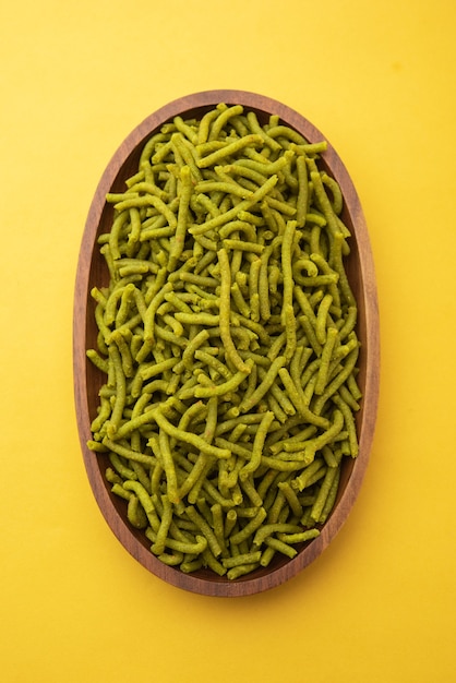 Gli spinaci o palak sev sono spaghetti salati fritti e croccanti. Shev o namkeen verde spesso e sottile fatto in casa è un classico spuntino indiano. servito in una ciotola o piatto