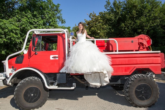 Gli sposi felici e adorabili sul camion dei pompieri rosso