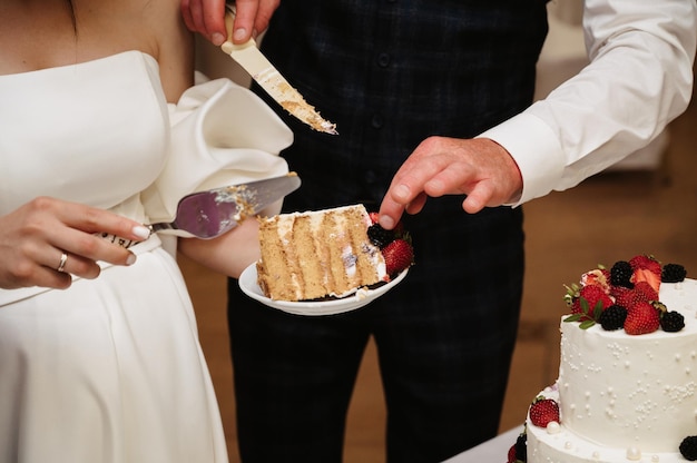 Gli sposi hanno tagliato a pezzi una torta nuziale festiva