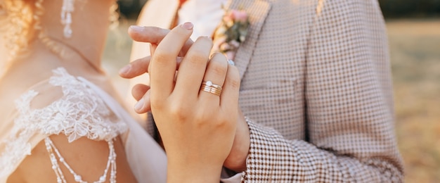 Gli sposi il giorno del matrimonio si abbracciano e mostrano amore al tramonto