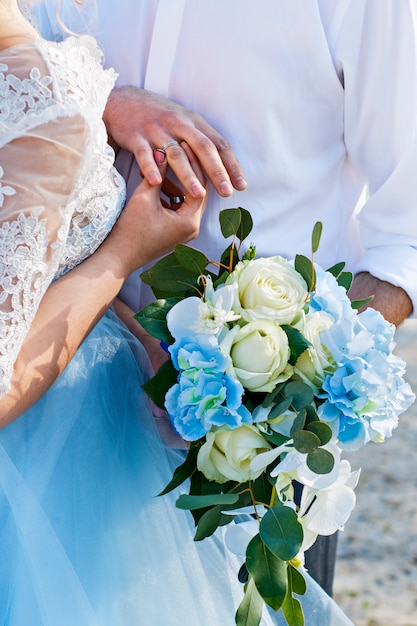 Gli sposi indossano anelli. Cerimonia matrimoniale. Il bouquet della sposa Sposa e sposo con anelli.